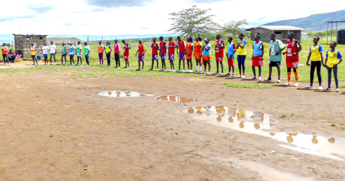 Spieler einer kenianischen Jugendfußballmannschaft stehen während eines Turniers eines sozialen Sportprojekts aufgereiht am Spielfeldrand und warten auf ihren Einsatz.