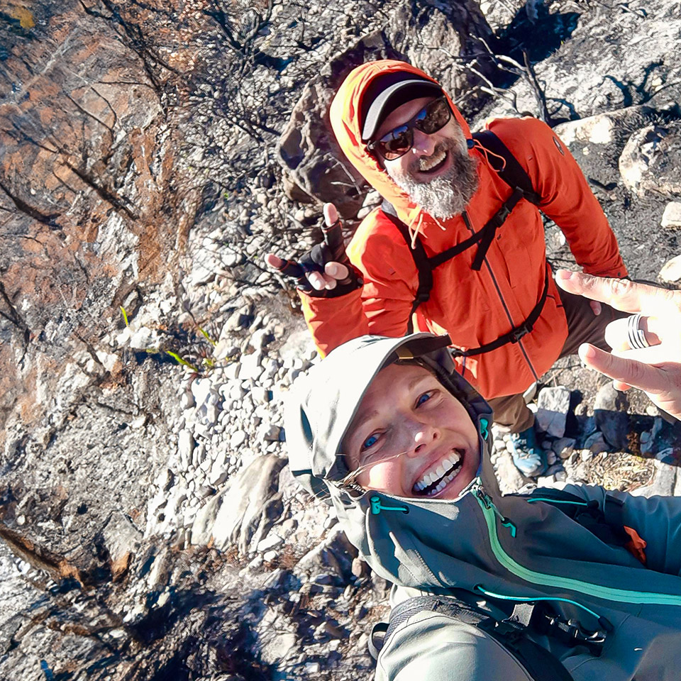 Nicola and Ronny from COACH ABROAD hiking on Table Mountain in windy conditions.