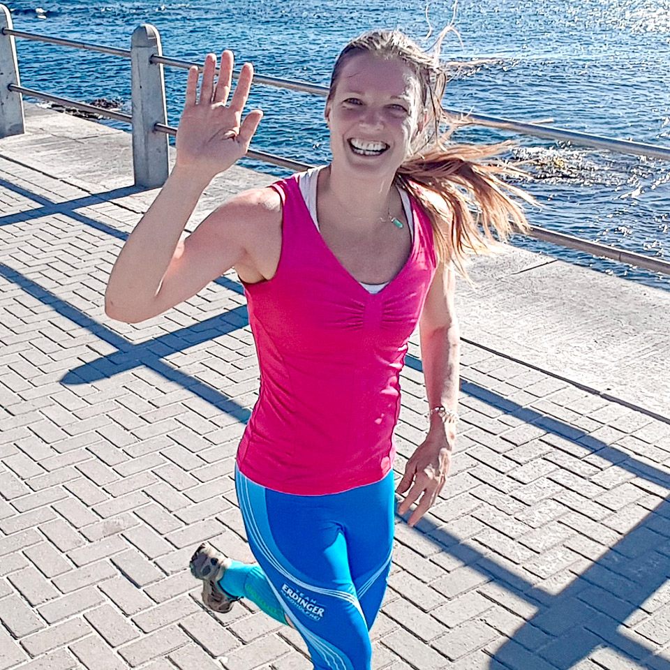 Profile picture of COACH ABROAD's Nicola Scholl running on the beach promenade in Cape Town.