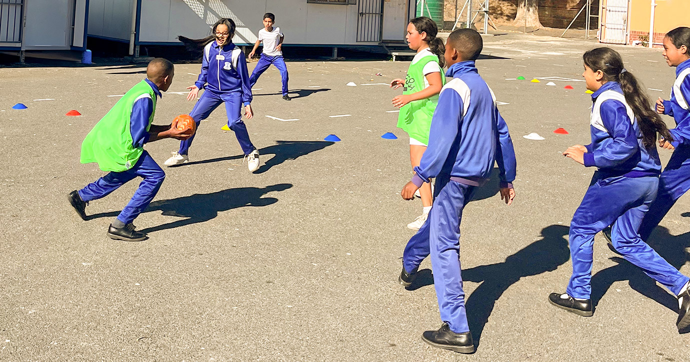 Kinder einer Schule in Kapstadt beim Handballtraining auf dem Schulhof